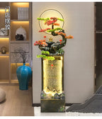 Moonlit Bonsai Waterfall against a pale wall near display shelves, a blue vase and a dark sculptural seat.