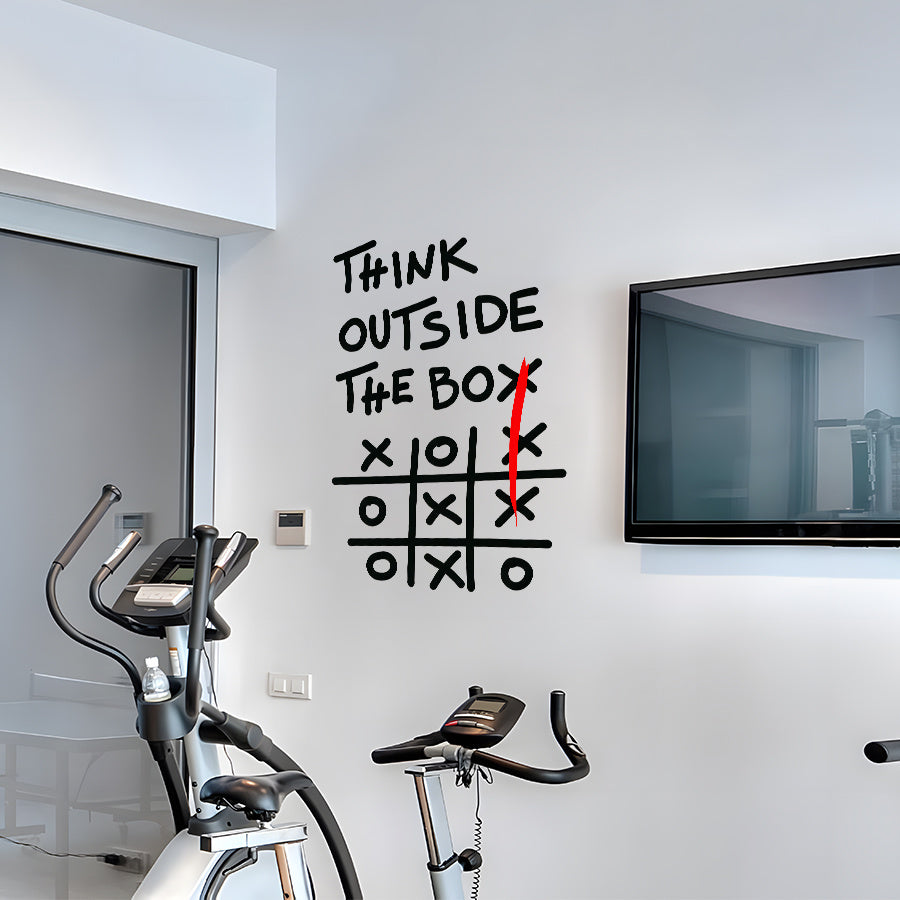 Outside The Box Decal displayed between a window and wall-mounted television in an exercise room