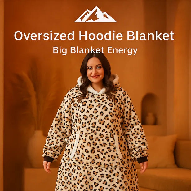 HighPeak Oversized Hoodie Blanket in leopard print sherpa fleece worn by smiling woman indoors