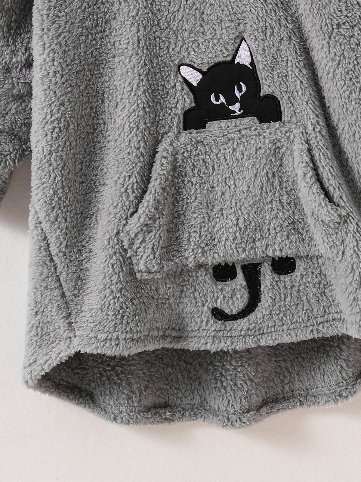 Peekaboo Cat Kids Hoodie close-up of the black cat face, front pocket, paws and tail