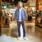 Personalized Person Cutout of a man in a blue outfit, displayed on a round base inside a clothing store.