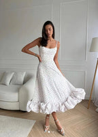 White floral-print ruffle dress with the skirt held outward; gallery style reference
