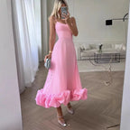 Pink spaghetti-strap Petal Waltz Ruffle Dress shown in a living room mirror