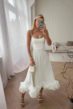 White Petal Waltz Ruffle Dress with spaghetti straps and a full ruffled hem, shown in a mirror