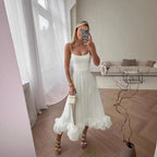 White Petal Waltz Ruffle Dress in a living room mirror with its sculpted ruffle hem
