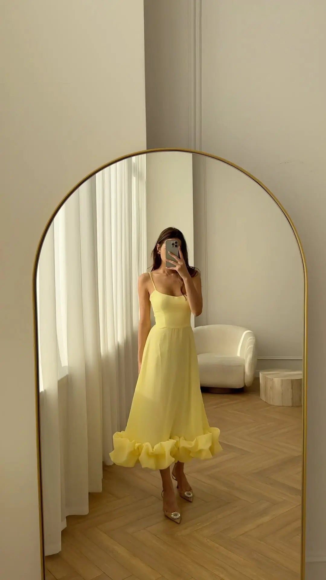 Full-length yellow ruffle dress with spaghetti straps in an arched mirror; gallery style reference