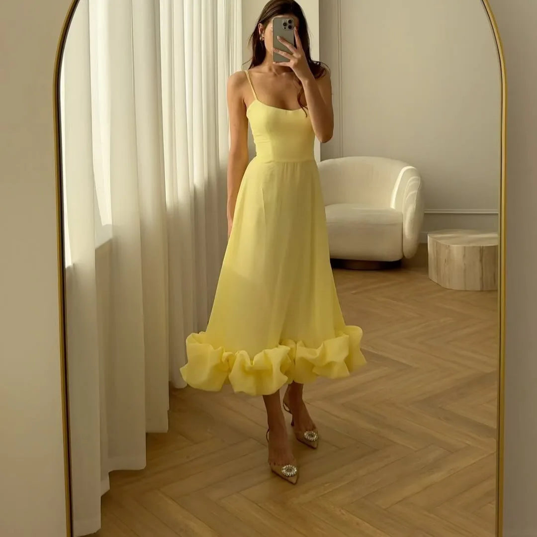 Yellow version of the ruffle dress shown in an arched mirror; gallery style reference