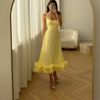 Yellow version of the ruffle dress shown in an arched mirror; gallery style reference