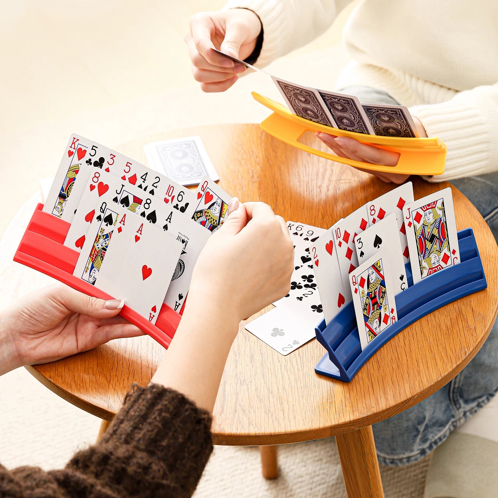 Playing Card Holder used by multiple players around a table with red, yellow, and blue colors