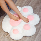 Plush Cat Paw Cushion in white laid flat on the floor to show its full paw shape
