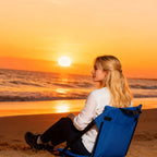 Portable Bleacher Seat in blue used on a sandy beach while watching the sunset over the water