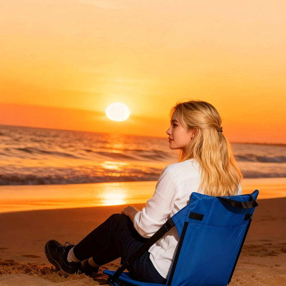 Portable Bleacher Seat in blue used on a sandy beach while watching the sunset over the water