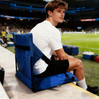 Portable Bleacher Seat in blue being used on stadium bleachers with the rear pocket and side straps visible