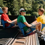 Portable Bleacher Seat shown in a group of three blue seats being used on a pickup truck tailgate