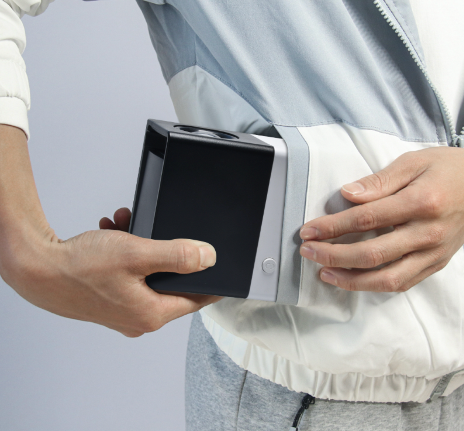 portable projector in black and silver, shown being held to demonstrate compact size and portability