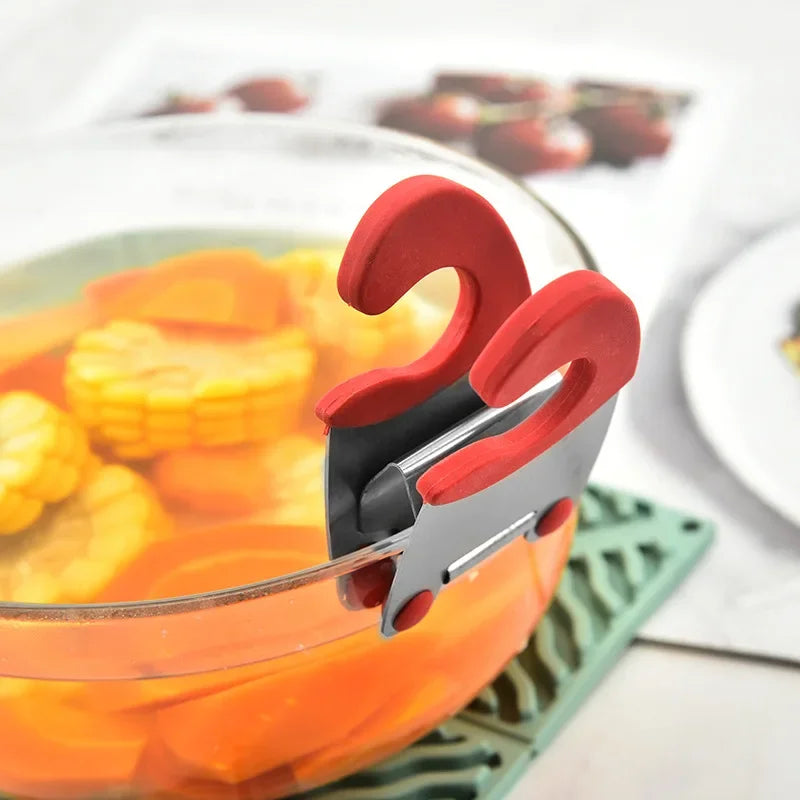 Red pot clip spoon holder attached to the rim of a glass bowl containing corn and carrots