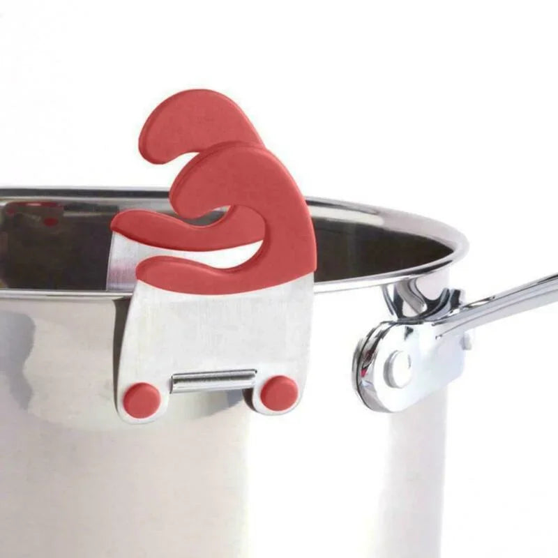 Red pot clip spoon holder attached to the rim of a stainless steel saucepan