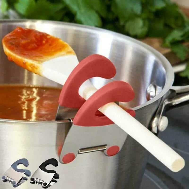 Red pot clip supporting a white spatula over tomato sauce with blue-gray and black holder insets