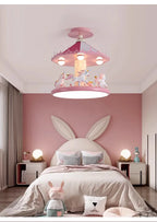 Pink carousel lamp in a bedroom with a bunny-ear headboard and rabbit toy on the floor
