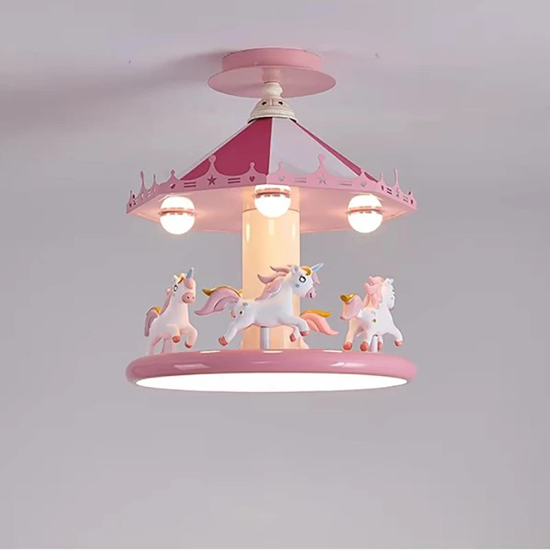 Illuminated pink carousel ceiling lamp with unicorn figures against a gray background