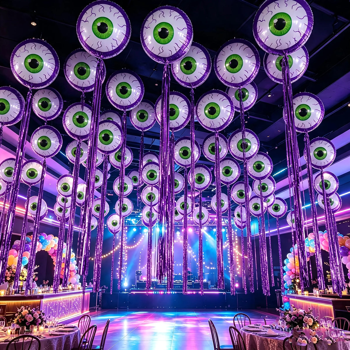 Purple Halloween Eyeball Balloons with long purple fringe decorating a colorful party hall ceiling.
