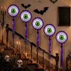 Purple Halloween Eyeball Balloons staggered along a staircase decorated with bats, skulls, and cobwebs.