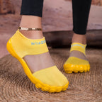 Quick-Dry Water Shoes yellow pair worn on a woven rug, showing mesh panels and rounded toes.