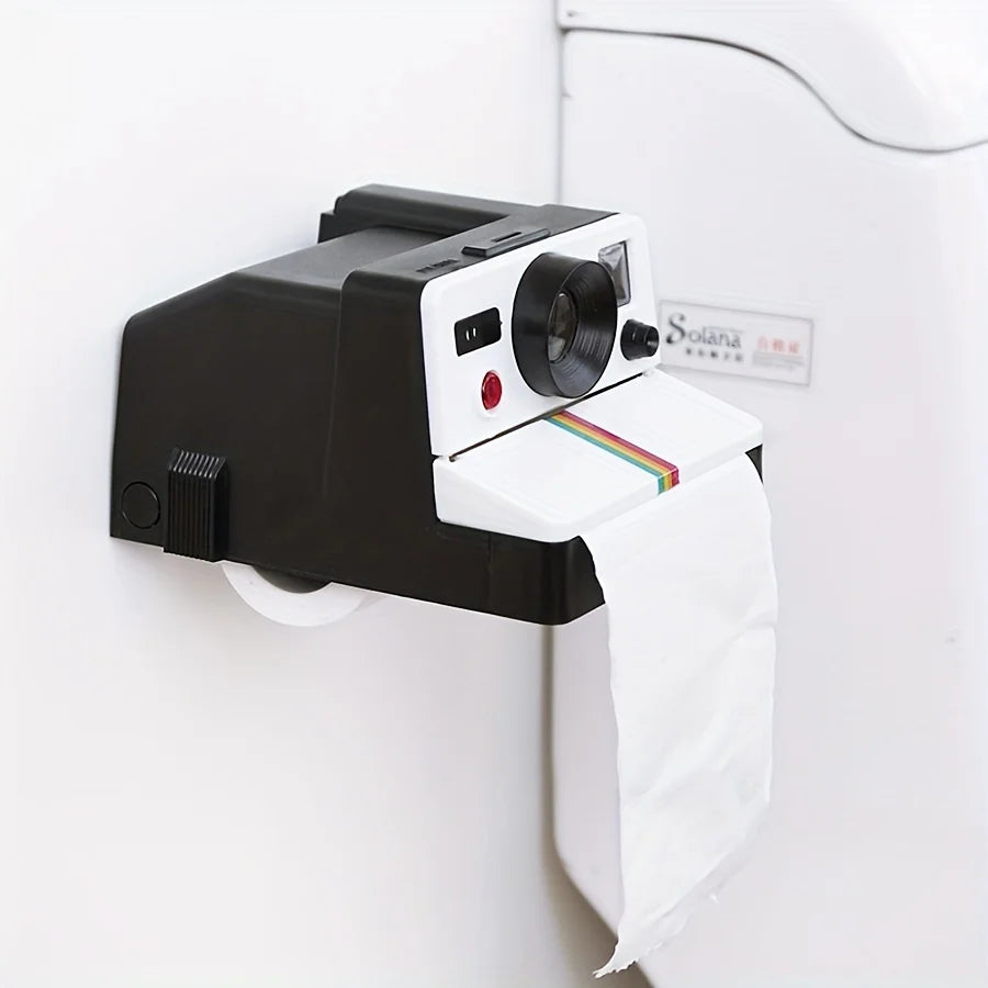 Retro Camera Toilet Paper Holder installed on a white bathroom wall with paper hanging below