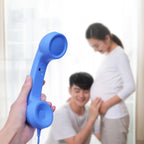 Hand holding the blue Retro Mobile Phone Handset with a family in the background