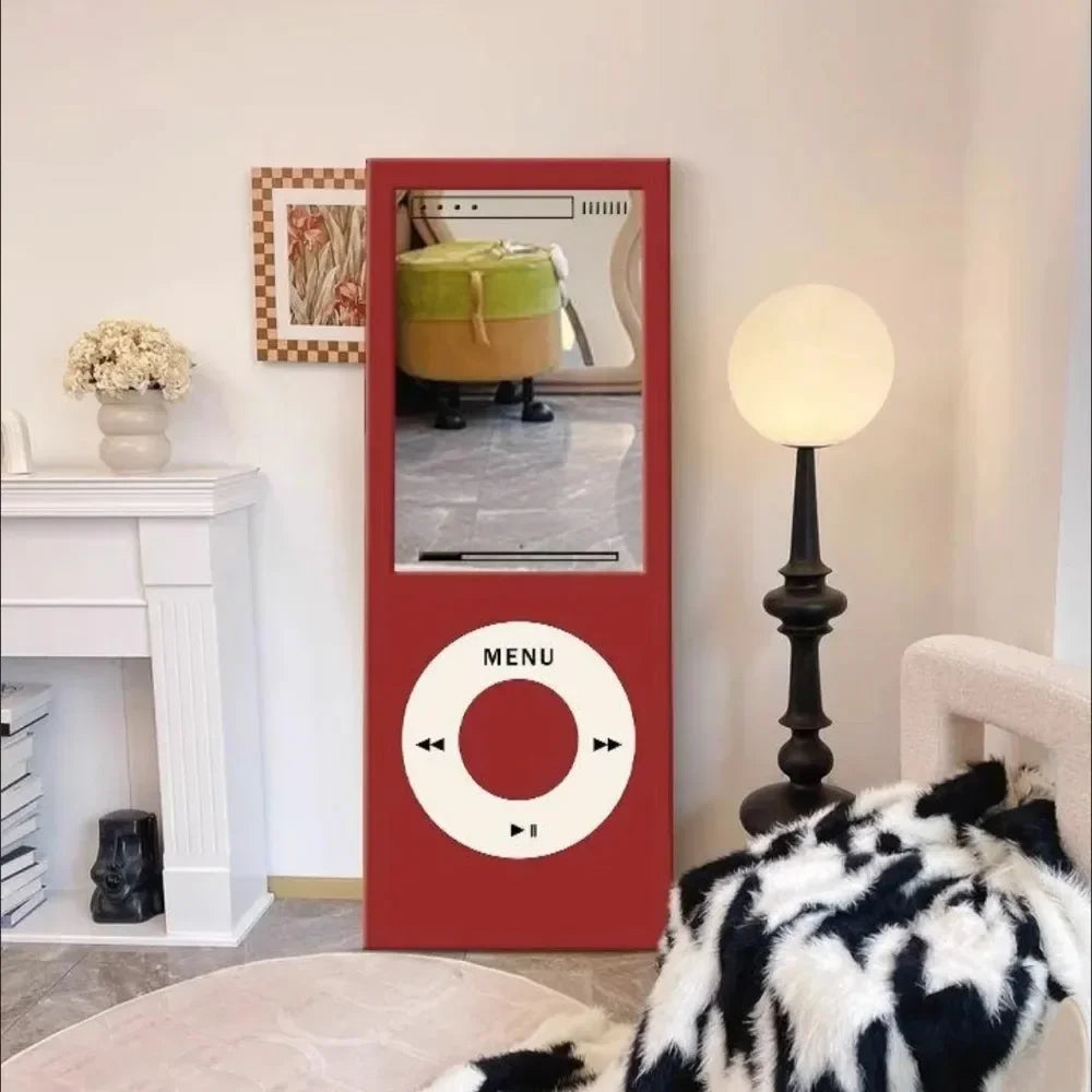 Retro MP3 Wall Mirror in red shown beside a white fireplace, globe floor lamp, and textured lounge chair
