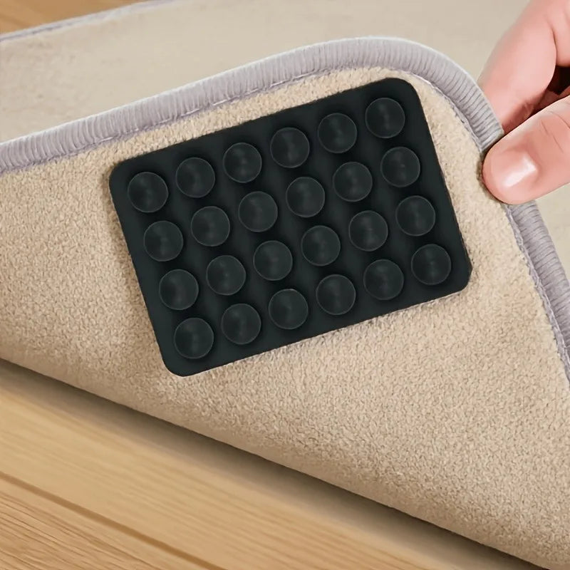 Reusable Rug Grippers black silicone pad installed beneath a beige rug on a smooth wood floor