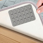 Reusable Rug Grippers grey silicone pad installed beneath a rug on a smooth wood floor
