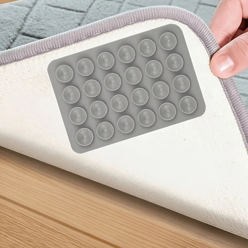 Reusable Rug Grippers grey silicone pad installed beneath a rug on a smooth wood floor