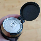 Reusable Soda Can Lid attached to a can held in one hand, showing the open lid and mounting ring.