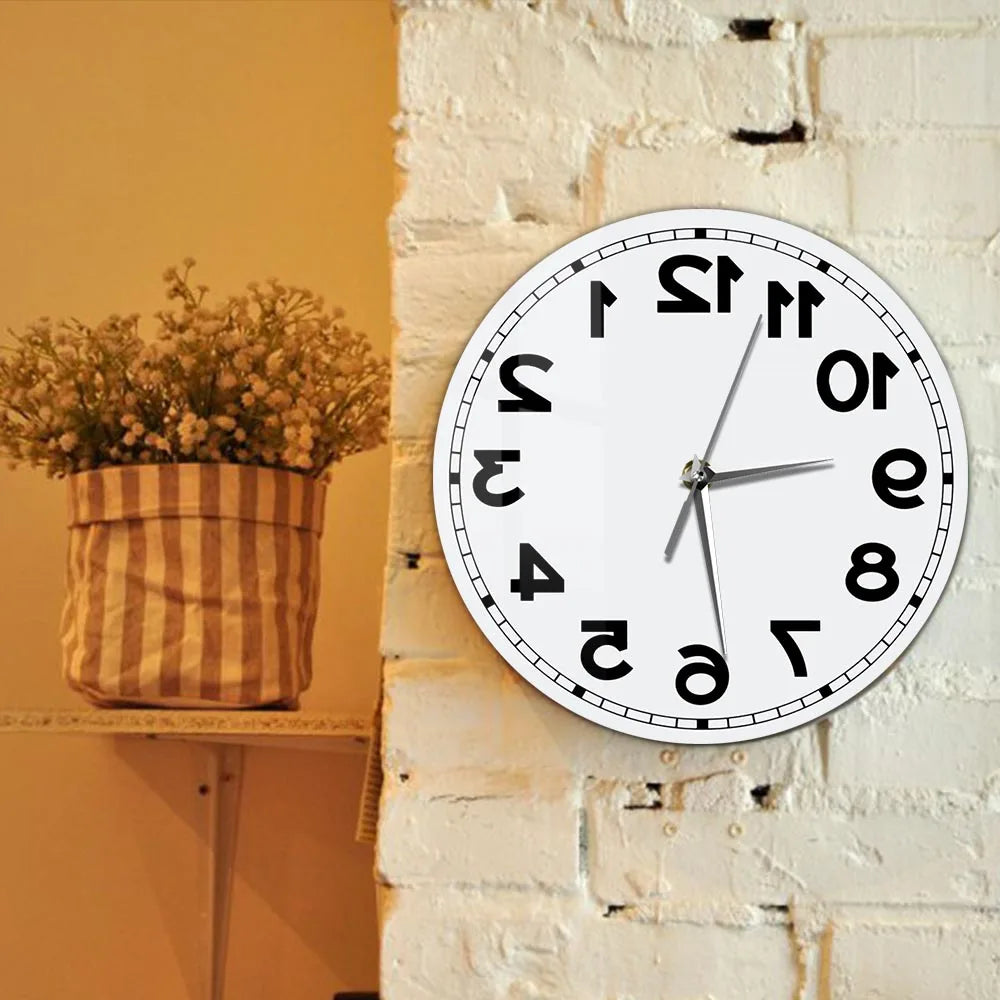 Frameless Reverse Number Wall Clock displayed on a white brick wall beside dried flowers
