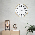 Wooden-frame Reverse Number Wall Clock displayed above a workspace on a white brick wall