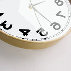 Close-up of the wooden frame and lower reversed numerals on the wall clock