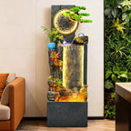 Rockery Water Fountain beside an orange sofa and green plant wall, with warm lighting along the water curtain.