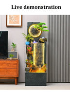 Rockery Water Fountain demonstration photo beside a TV cabinet and gray vertical wall panels.