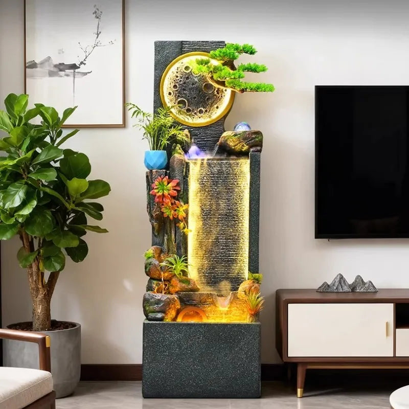 Rockery Water Fountain between a leafy potted tree and television cabinet in a living room.