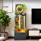 Rockery Water Fountain between a leafy potted tree and television cabinet in a living room.