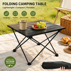 Roll-Up Camping Table picnic setup showing the black table with fruit, a mug, and the packed carry bag.