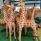 Safari Giraffe Stuffed Animal group of brown and cream giraffe plush toys in a supplier workshop.