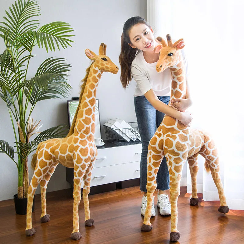 Safari Giraffe Stuffed Animal a woman standing and hugging one of two giraffes.