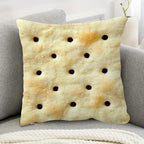 Saltine Cracker Pillow Cover styled on a gray sofa with the cracker print facing forward