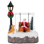 Front view of Santa Swing Christmas Scene with dog, tree, snowy base and glowing lamppost on white
