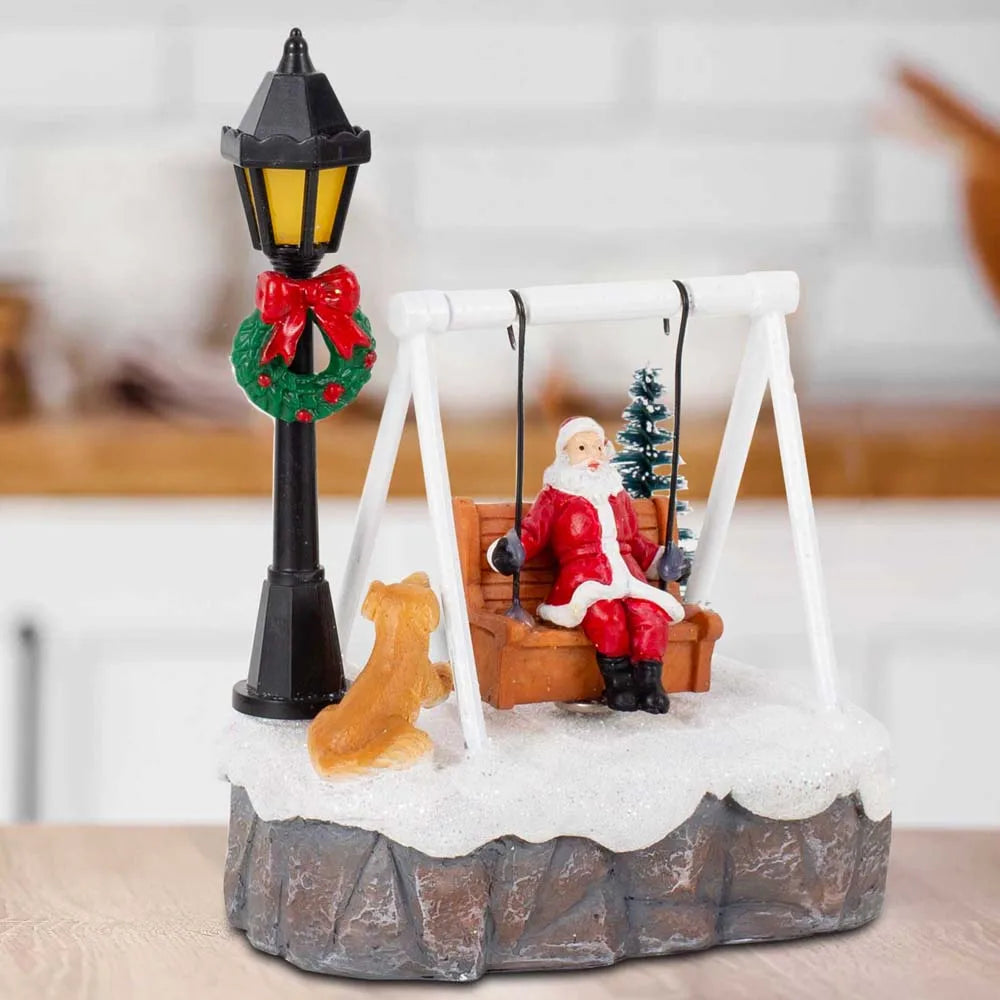 Three-quarter view of Santa Swing Christmas Scene showing swing, dog, tree and lamppost in a home setting