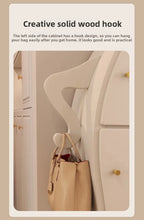Sassy Pants Drawer Cabinet: Close-up of the bent white arm hook holding a beige handbag.