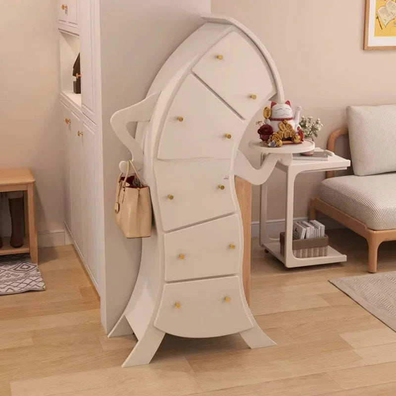 Sassy Pants Drawer Cabinet: Additional living room view of the white cabinet with gold-tone knobs and a side bag.