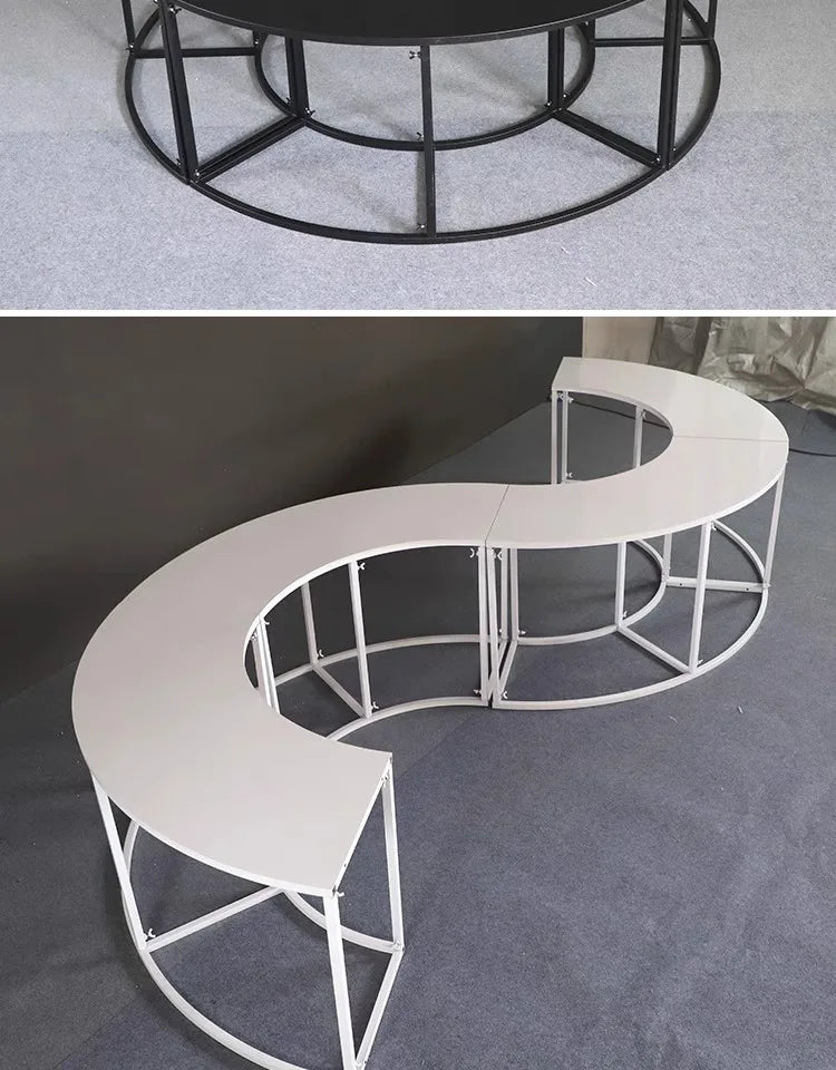 Serpentine Event Display Table white S-shaped arrangement indoors beneath a cropped view of a black round frame.